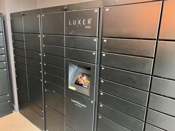 A wall of black lockers with the word LUXE on the top.